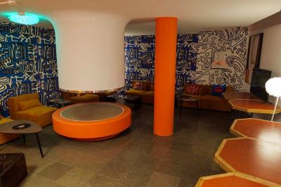 Mur décoré de vinyles, panneau des Rolling Stones et lampes modernes, avec un papier peint coloré en arrière-plan.