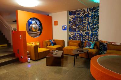 Mur décoré de vinyles, panneau des Rolling Stones et lampes modernes, avec un papier peint coloré en arrière-plan.