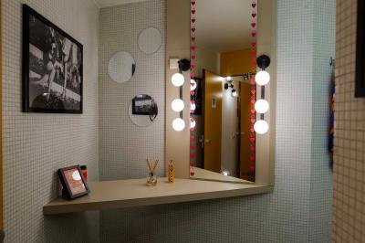 Mur décoré de vinyles, panneau des Rolling Stones et lampes modernes, avec un papier peint coloré en arrière-plan.