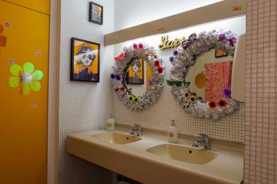 Mur décoré de vinyles, panneau des Rolling Stones et lampes modernes, avec un papier peint coloré en arrière-plan.