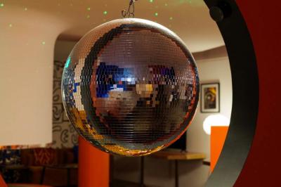 Mur décoré de vinyles, panneau des Rolling Stones et lampes modernes, avec un papier peint coloré en arrière-plan.