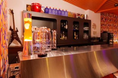 Mur décoré de vinyles, panneau des Rolling Stones et lampes modernes, avec un papier peint coloré en arrière-plan.