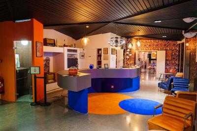 Mur décoré de vinyles, panneau des Rolling Stones et lampes modernes, avec un papier peint coloré en arrière-plan.