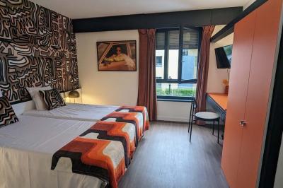 Mur décoré de vinyles, panneau des Rolling Stones et lampes modernes, avec un papier peint coloré en arrière-plan.