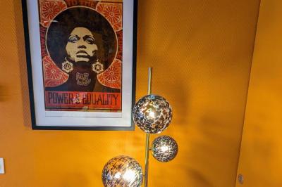 Mur décoré de vinyles, panneau des Rolling Stones et lampes modernes, avec un papier peint coloré en arrière-plan.