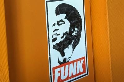 Mur décoré de vinyles, panneau des Rolling Stones et lampes modernes, avec un papier peint coloré en arrière-plan.