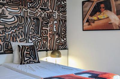 Mur décoré de vinyles, panneau des Rolling Stones et lampes modernes, avec un papier peint coloré en arrière-plan.