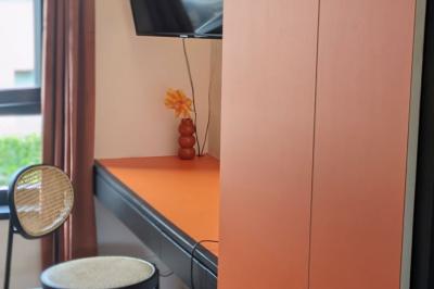 Mur décoré de vinyles, panneau des Rolling Stones et lampes modernes, avec un papier peint coloré en arrière-plan.