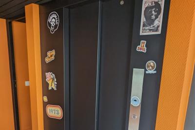 Mur décoré de vinyles, panneau des Rolling Stones et lampes modernes, avec un papier peint coloré en arrière-plan.