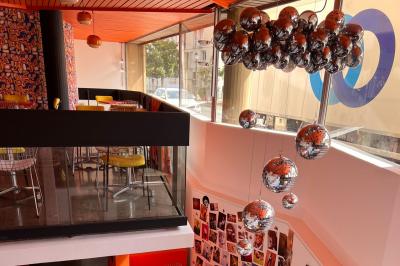 Mur décoré de vinyles, panneau des Rolling Stones et lampes modernes, avec un papier peint coloré en arrière-plan.