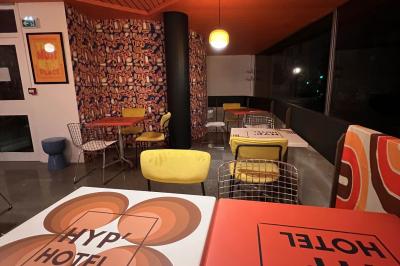 Mur décoré de vinyles, panneau des Rolling Stones et lampes modernes, avec un papier peint coloré en arrière-plan.