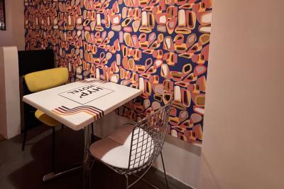 Mur décoré de vinyles, panneau des Rolling Stones et lampes modernes, avec un papier peint coloré en arrière-plan.