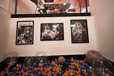 Mur décoré de vinyles, panneau des Rolling Stones et lampes modernes, avec un papier peint coloré en arrière-plan.