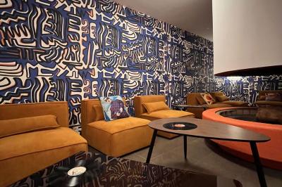 Mur décoré de vinyles, panneau des Rolling Stones et lampes modernes, avec un papier peint coloré en arrière-plan.