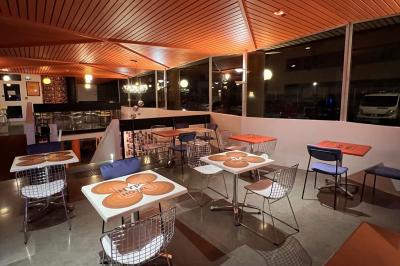 Mur décoré de vinyles, panneau des Rolling Stones et lampes modernes, avec un papier peint coloré en arrière-plan.