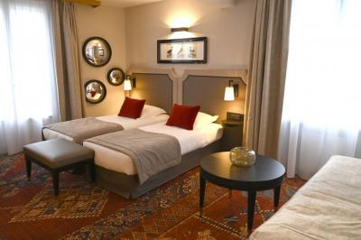 Bateau de plaisance naviguant sur une rivière bordée de maisons anciennes et d'arbres alignés.