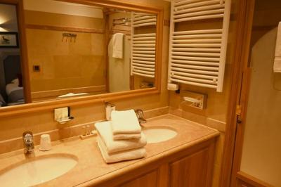 Bateau de plaisance naviguant sur une rivière bordée de maisons anciennes et d'arbres alignés.