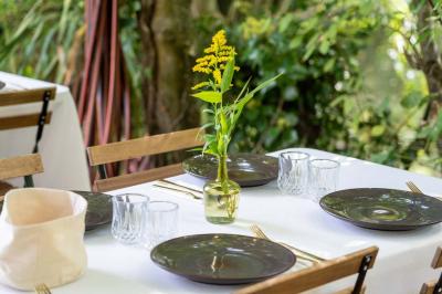 Tables dressées avec nappes blanches, vaisselle élégante, verres à pied et décorations florales sous des tonnelles…