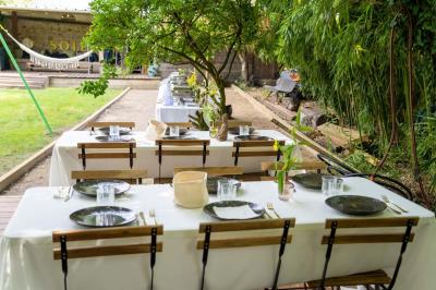Tables dressées avec nappes blanches, vaisselle élégante, verres à pied et décorations florales sous des tonnelles…