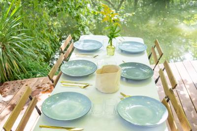 Tables dressées avec nappes blanches, vaisselle élégante, verres à pied et décorations florales sous des tonnelles…