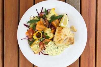 Pièce montée en choux décorée de cœurs blancs, posée sur une table avec des desserts et une plaque personnalisée.