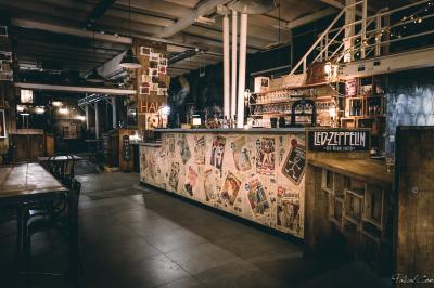 Un chandelier avec des bougies allumées posé près d'une ancienne presse métallique dans un décor artistique.