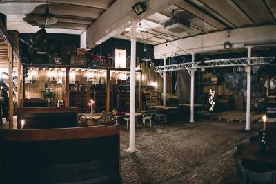 Un chandelier avec des bougies allumées posé près d'une ancienne presse métallique dans un décor artistique.