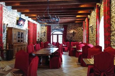 Château en pierre entouré d'arbres et de pelouses bien entretenues, avec un drapeau au sommet de la tour.