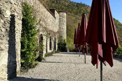 Château en pierre entouré d'arbres et de pelouses bien entretenues, avec un drapeau au sommet de la tour.