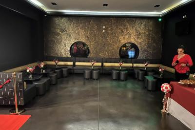 Escalier décoré de guirlandes lumineuses, de feuillage vert et de nœuds rouges, avec des sacs cadeaux posés sur les marches.