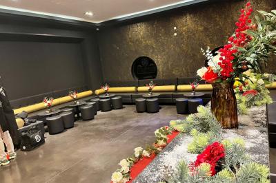 Escalier décoré de guirlandes lumineuses, de feuillage vert et de nœuds rouges, avec des sacs cadeaux posés sur les marches.