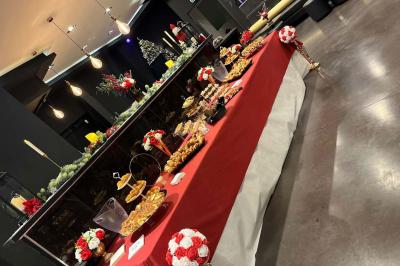 Escalier décoré de guirlandes lumineuses, de feuillage vert et de nœuds rouges, avec des sacs cadeaux posés sur les marches.