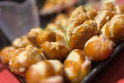 Escalier décoré de guirlandes lumineuses, de feuillage vert et de nœuds rouges, avec des sacs cadeaux posés sur les marches.