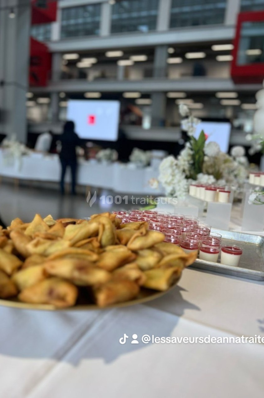 Assortiment de samoussas et verrines sucrées disposés sur une table lors d'un événement en intérieur.
