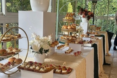 Miniature Traiteur Décines-Charpieu (Rhône) - Les Saveurs de Anna Traiteur #12 Assortiment de samoussas dorés et verrines disposés sur une table lors d'un événement dans un espace moderne.