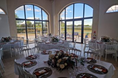 Salle de conférence lumineuse avec rangées de chaises blanches, un pupitre et un micro au premier plan.