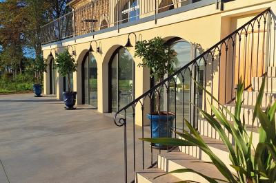 Salle de conférence lumineuse avec rangées de chaises blanches, un pupitre et un micro au premier plan.