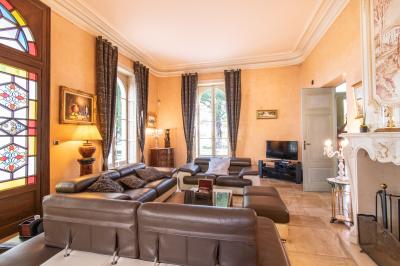 Salle de conférence lumineuse avec rangées de chaises blanches, un pupitre et un micro au premier plan.