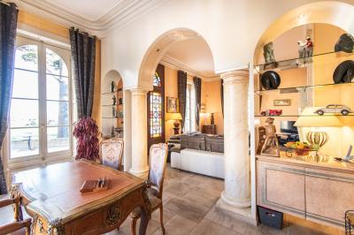 Vue d'un bassin avec toboggans aquatiques, entouré de végétation, de rochers et de jarres décoratives.