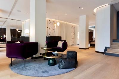 Motif mural en écailles beige, noir et doré, encadré par des rideaux blancs.