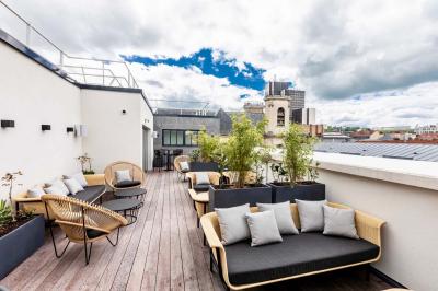 Motif mural en écailles beige, noir et doré, encadré par des rideaux blancs.