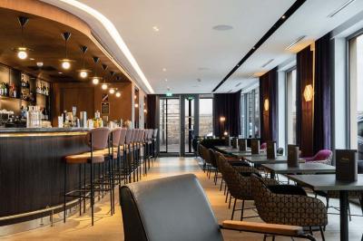 Motif mural en écailles beige, noir et doré, encadré par des rideaux blancs.