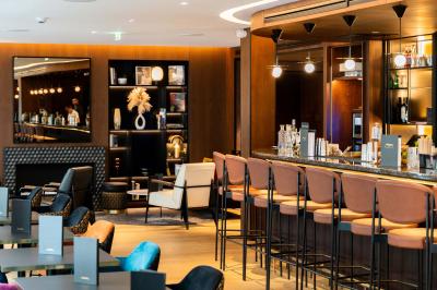 Motif mural en écailles beige, noir et doré, encadré par des rideaux blancs.