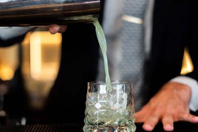 Motif mural en écailles beige, noir et doré, encadré par des rideaux blancs.