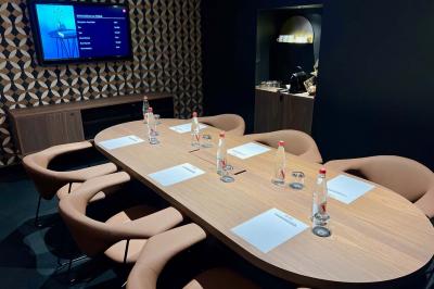 Motif mural en écailles beige, noir et doré, encadré par des rideaux blancs.