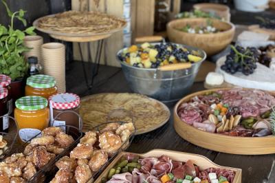 Deux chevaux blancs derrière une clôture en bois, entourés d'herbes hautes sous un ciel bleu.