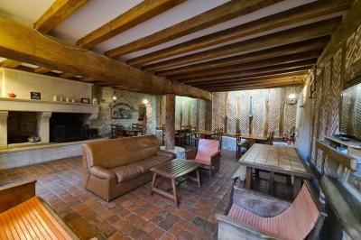 Vue d'un bar rustique en pierre et bois avec éclairage suspendu dans une pièce au style traditionnel.