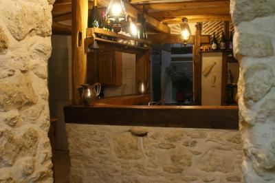 Vue d'un bar rustique en pierre et bois avec éclairage suspendu dans une pièce au style traditionnel.