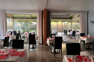 Lit double avec linge de lit jaune et blanc, éclairé par deux appliques murales, devant un tableau de fleurs.