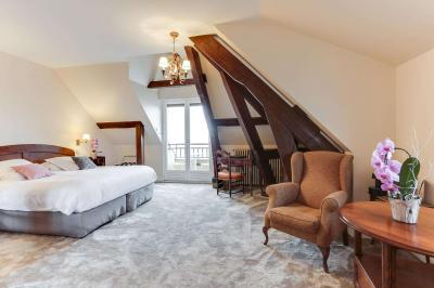 Chambre avec murs en bois, lit simple, bureau, fenêtre avec rideaux fleuris et lumière naturelle.